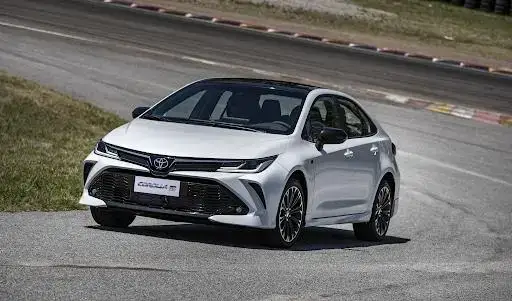 Toyota Corolla branco em uma pista de corrida, um carro confortável e moderno com recursos avançados.