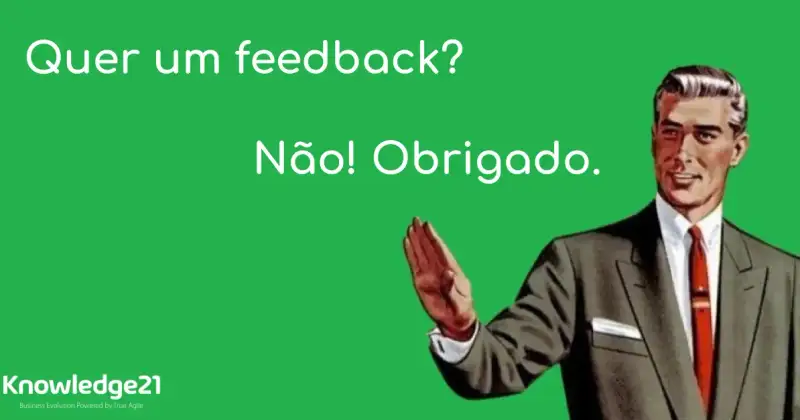 O título do texto como se fosse alguém dialogand com o meme de um homem com a mão estendida fazendo o sinal de pare. A pessoa que não aparece na imagem pergunta: Quer um feedback? O homem responde: Não! Obrigado. O Logo da K21 aparece no canto esquerdo