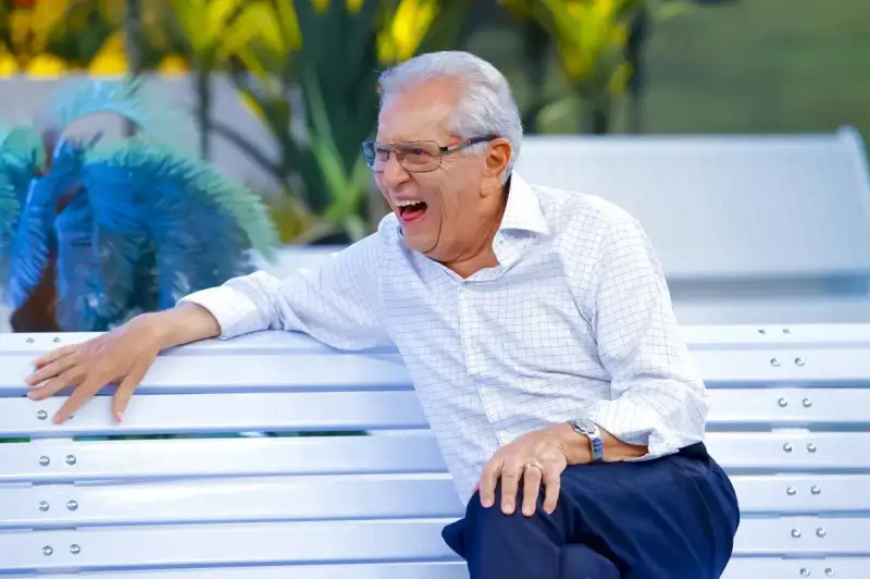 Carlos Alberto da Nóbrega sentado no Banco do programa A Praça é Nossa representando uma retrospectiva em que nada muda